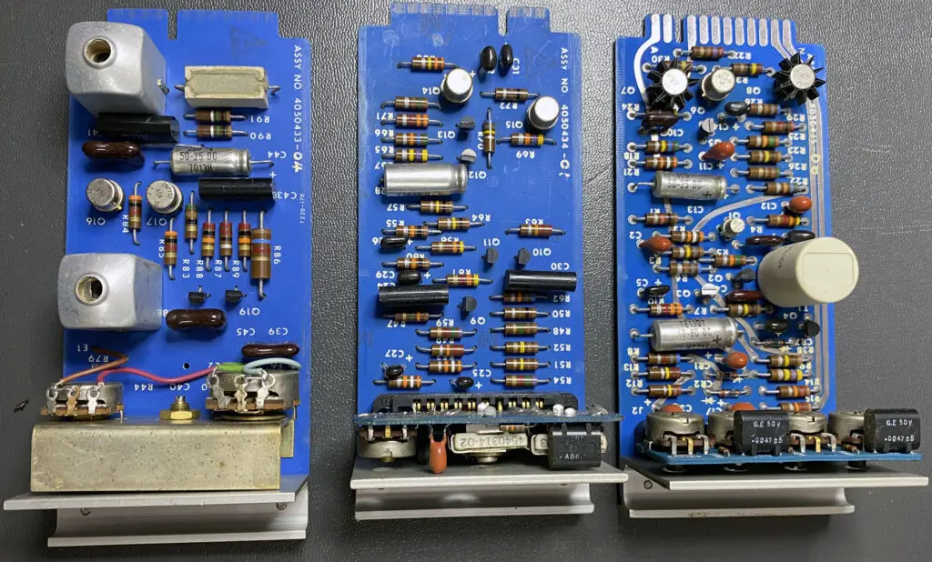 Three blue boards with many different electronic components.