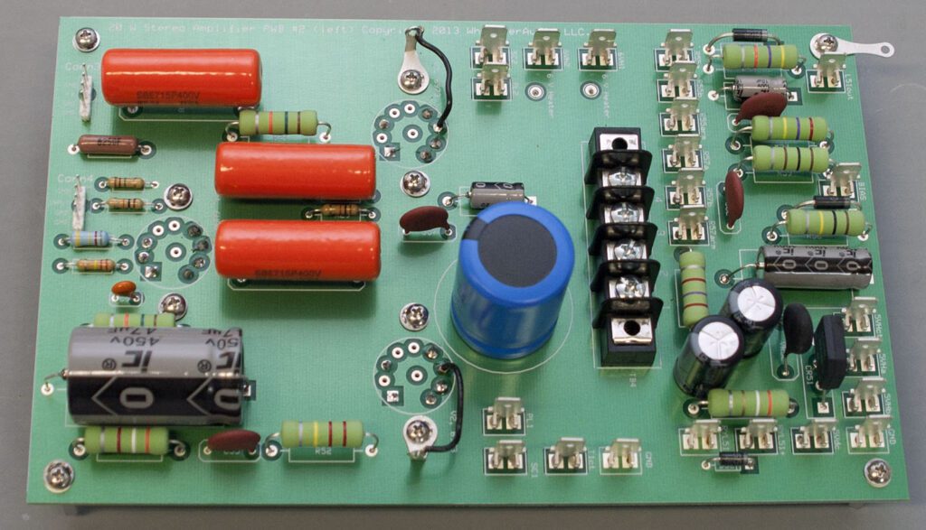 A green board with many different electronic components.