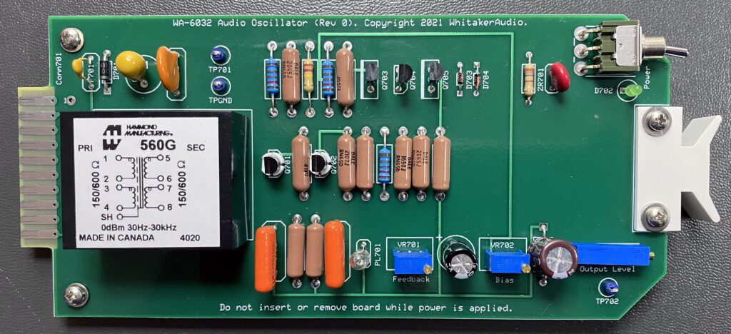 A green board with many different electronic components.