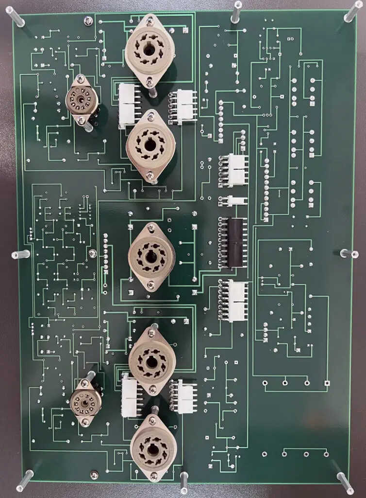 A green circuit board with many wires and buttons.