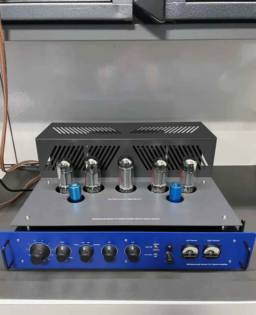 A blue and silver amplifier sitting on top of a table.