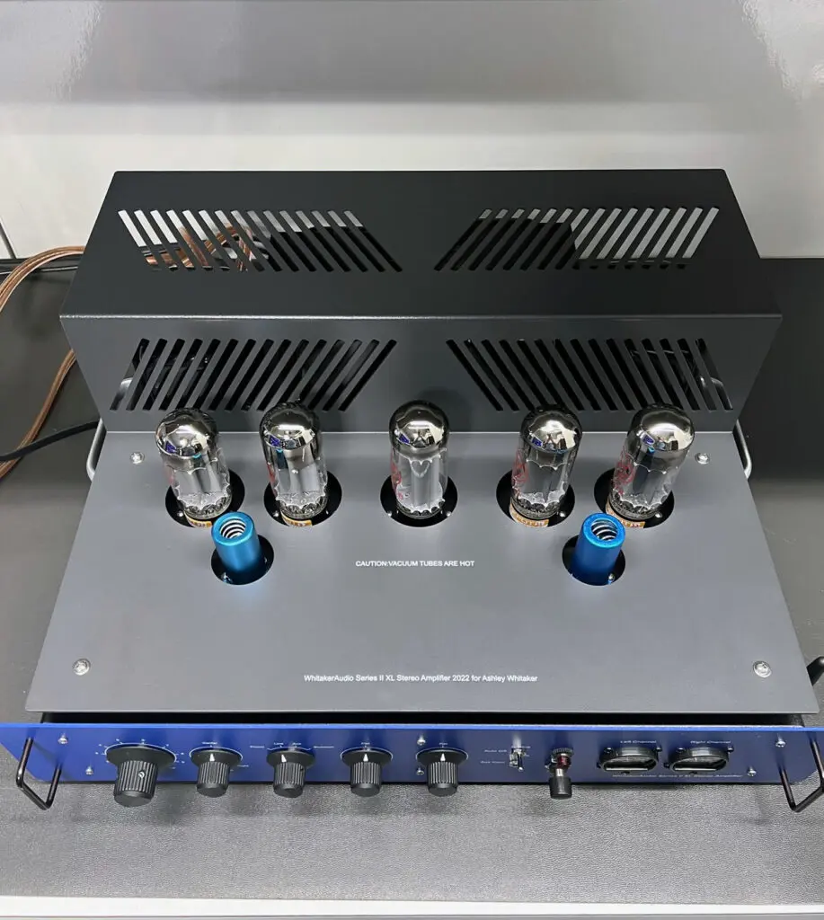 A blue and silver amplifier sitting on top of a table.