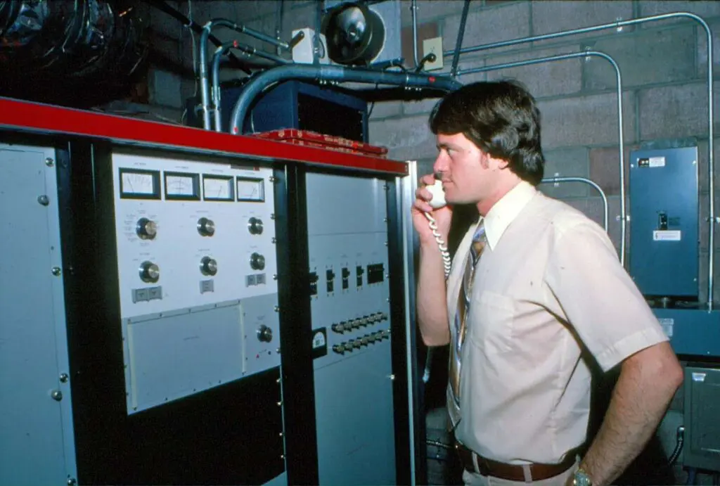 A man standing next to an electrical panel.