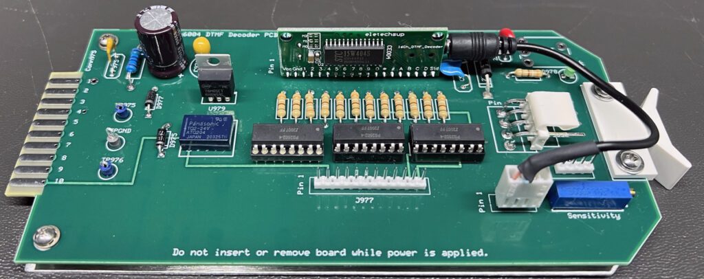 A green board with many electronic components on it