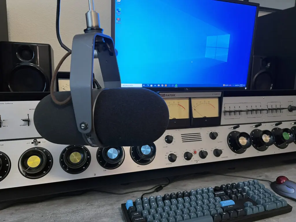 A computer keyboard and monitor with headphones on it.