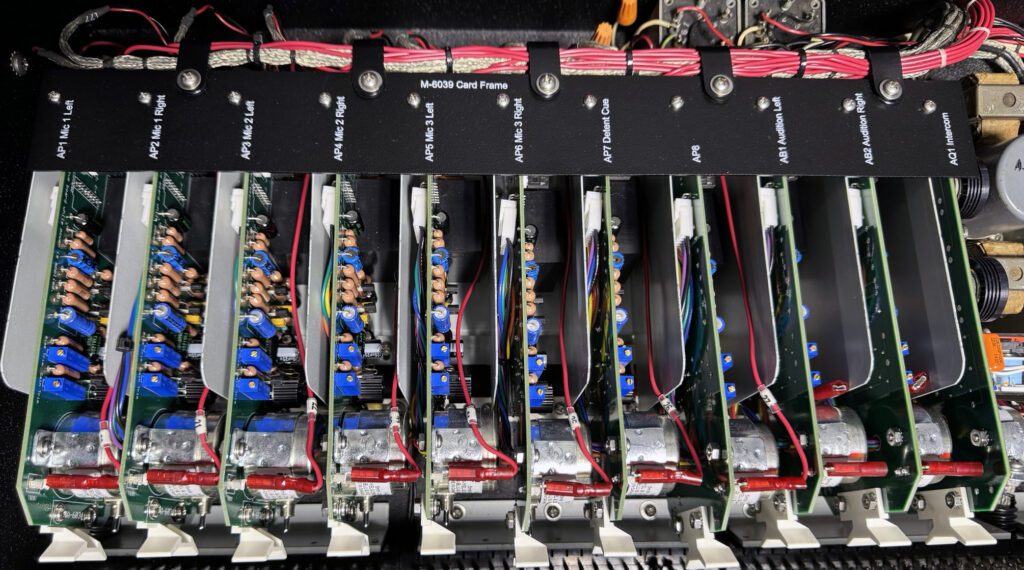 A row of computer motherboards with wires attached.