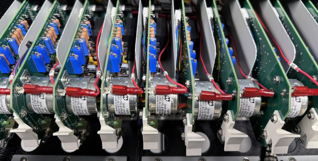 A row of computer power supplies sitting on top of each other.